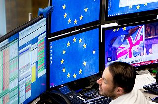 A computer screen shows news about the Brexit as a broker watches his screens at the stock market in Frankfurt, Germany, Wednesday, Jan. 16, 2019.