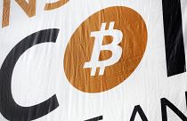 FILE: a bitcoin logo is displayed at the Inside Bitcoins conference and trade show, April 7, 2014 in New York.