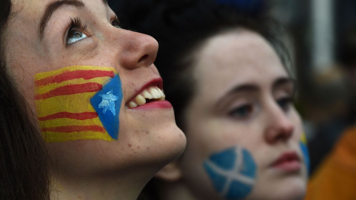 Demonstrators with the Catalan Estelada flag (left) and the Saltire painted on their faces during a protest to show solidarity with Catalonia in central Glasgow.
