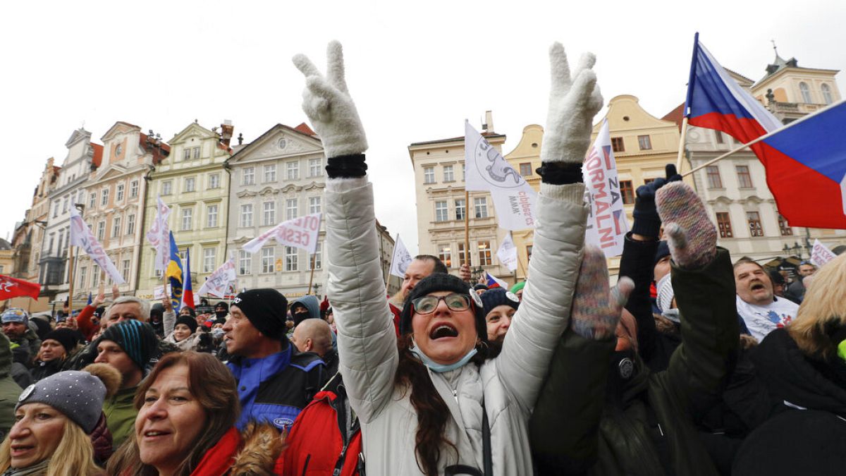 A woman flashes victory signs during a protest joined by thousands against the government restrictive measures to curb the spread of COVID-19 infections.