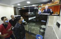 People in a restaurant watch President Abdelmadjid Tebboune's address on Thursday night