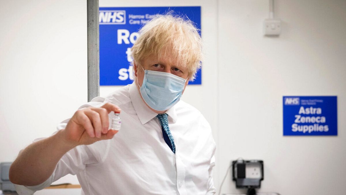 UK Prime Minister Boris Johnson holds a vial of the Oxford AstraZeneca COVID-19 vaccine during a visit of a coronavirus vaccination centre in London, Jan. 25, 2021