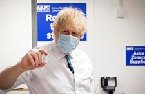 UK Prime Minister Boris Johnson holds a vial of the Oxford AstraZeneca COVID-19 vaccine during a visit of a coronavirus vaccination centre in London, Jan. 25, 2021