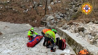 Italy's National Alpine and Speleological Rescue Corps rescue an injured man and his dog on February 18, 2021.