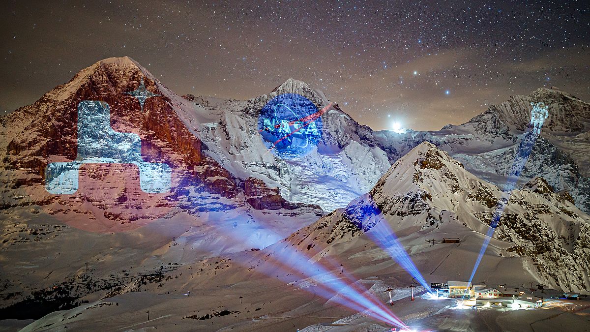 A giant projection of the NASA logos on the Bernese Alps mountains by Swiss light artist Gerry Hofstetter. Mannlichen, Switzerland. February 14, 2021