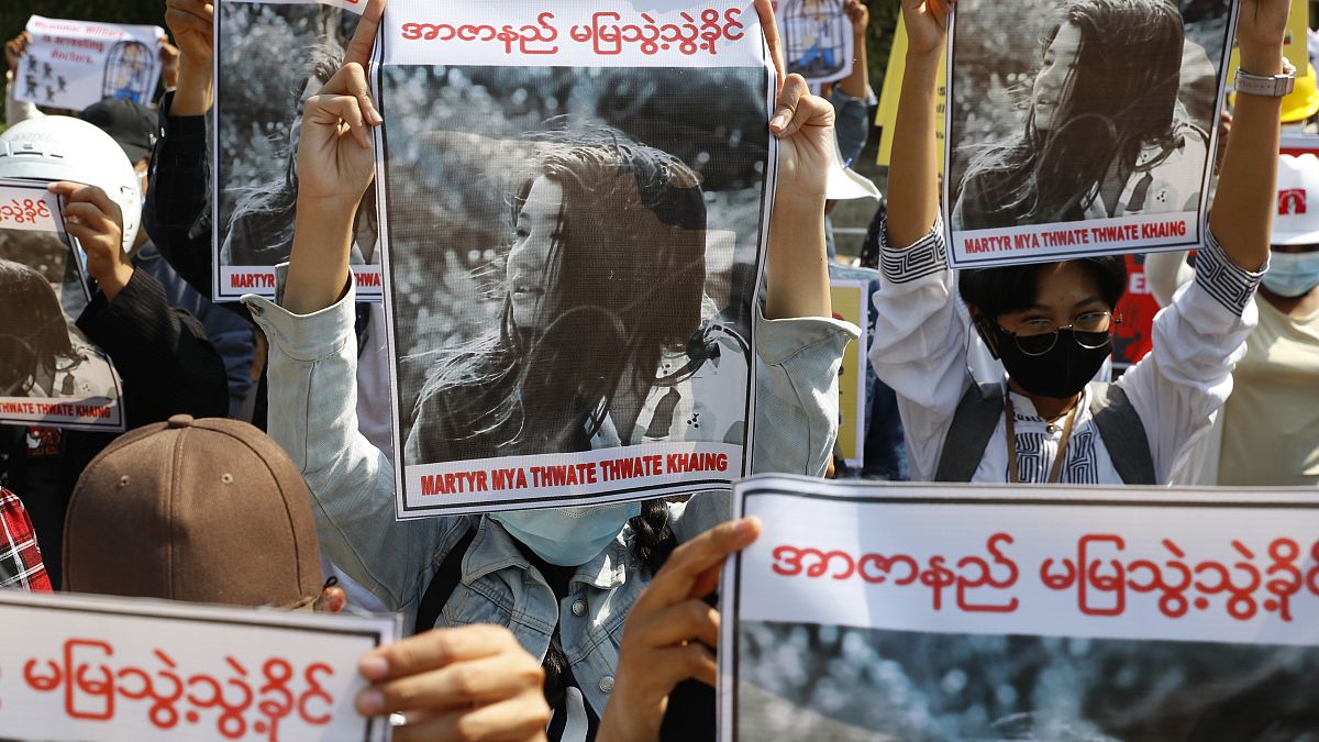 Manifestantes empunhando a fotografia de Mya Thwet Thwet Khine, baleada na cabeça