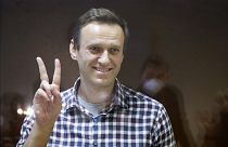 Russian opposition leader Alexei Navalny stands in a cage in the Babuskinsky District Court in Moscow, Russia, Saturday, Feb. 20, 2021.