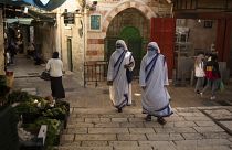 Maszkot viselő katolikus apácák sétálnak a jeruzsálemi óvárosban 2020. október 21-én