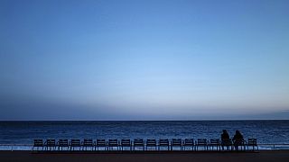 Deux personnes assises face à la mer, sur la Promenade des Anglais, à Nice, le 21 février 2021