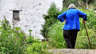 A lady walks in the countryside near her home. 