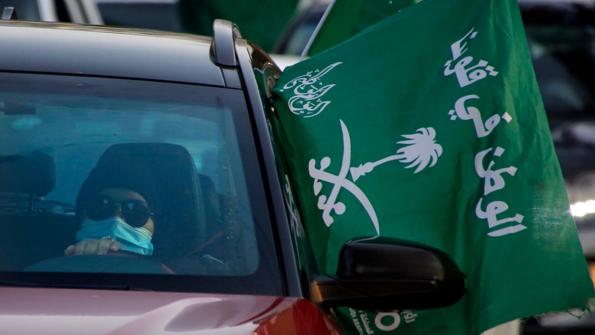 امرأة تحمل علما في السعودية