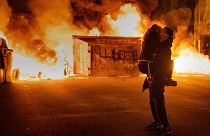 A couple kiss in front of a burning barricade in Barcelona at a protest condemning the arrest of Pablo Hasél