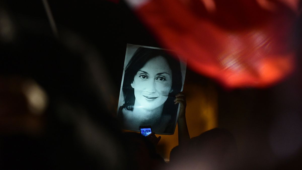A protester holds up a picture of murdered reporter Daphne Caruana Galizia.