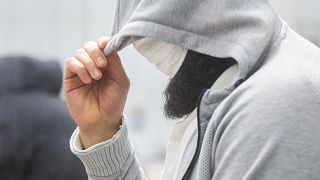 A man who calls himfelf Abu Walaa, alleged leader of the terrorist militia Islamic State (IS) in Germany, hides his face at the Higher Regional Court in Celle, Germany.