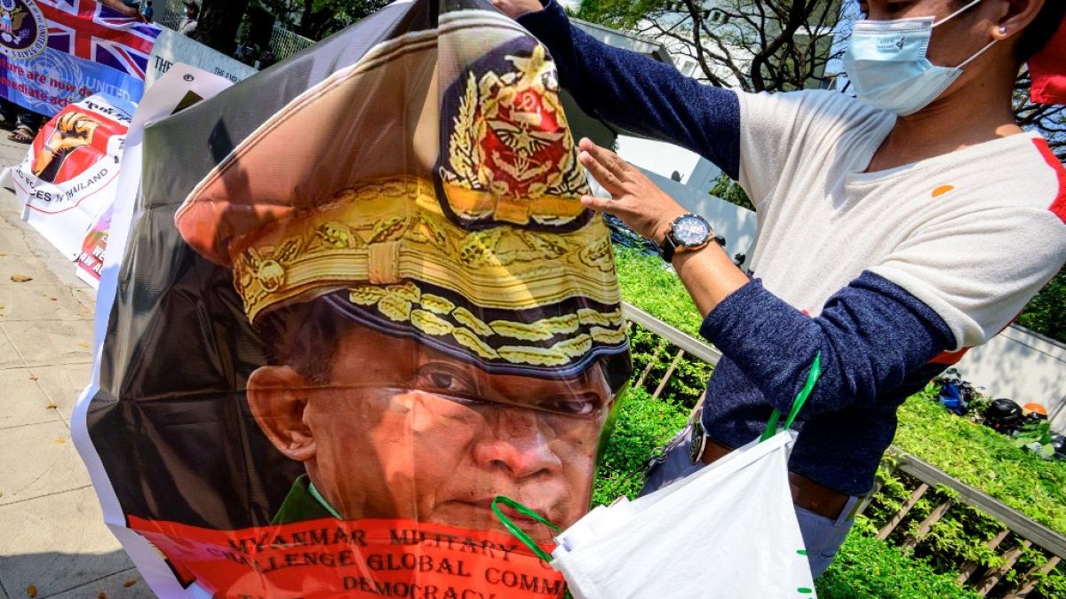 En Tha¨ïlande, un migrant birman tient un poster du général General Min Aung Hlaing (Bangkok, 18 février 2021)