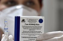 عامل في القطاع الطبي في مونتينيغرو رافعاً اللقاح الروسي سبوتنيك-في 