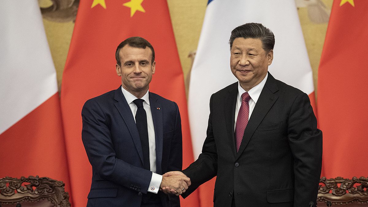 الرئيس الفرنسي إيمانويل ماكرون يصافح الرئيس الصيني شي جينبينغ في قاعة الشعب الكبرى في بكين، الصين 2019. 