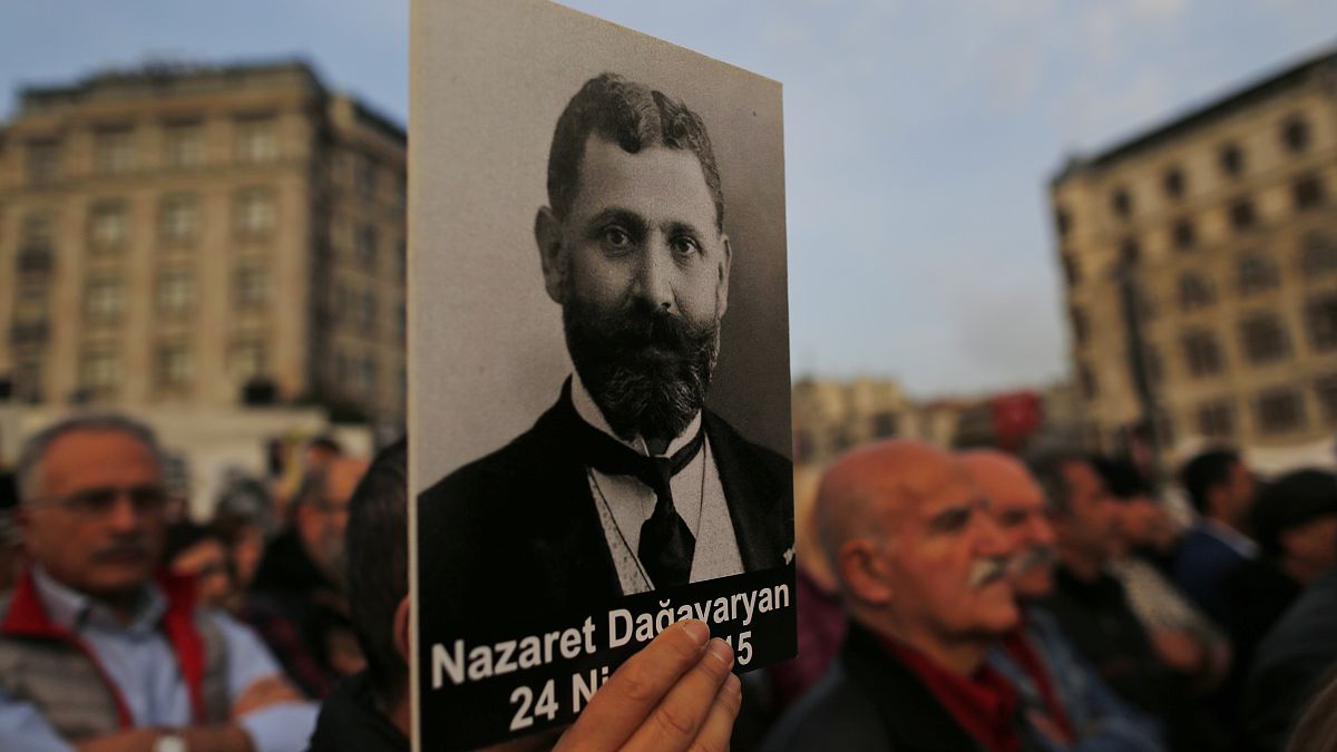 متظاهر يحمل صورة لمثقف أرمني خلال تجمع لإحياء الذكرى السنوية لقتل الأرمن عام 1915 في مدينة إسطنبول.