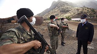 Turkish Defense Minister Hulusi Akar, fright wearing a face mask to protect against coronavirus, visits Turkish troops at the border with Iraq, in Hakkari province, Turkey.