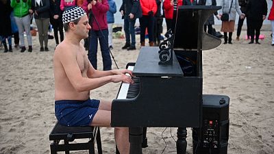 Polish winter swimmers fundraise with Baltic dip and beach piano tunes