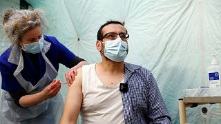 A man receives a dose of the AstraZeneca COVID-19 vaccine at pop up vaccination drive called Vaxi Taxi in Kilburn, London, Feb. 28, 2021. 