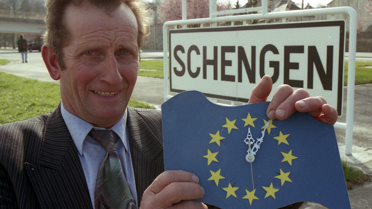 FILE: Mayor Norbert Redlinger poses with an Europe clock in front of the town sign of Schengen, Luxembourg March 24, 1995