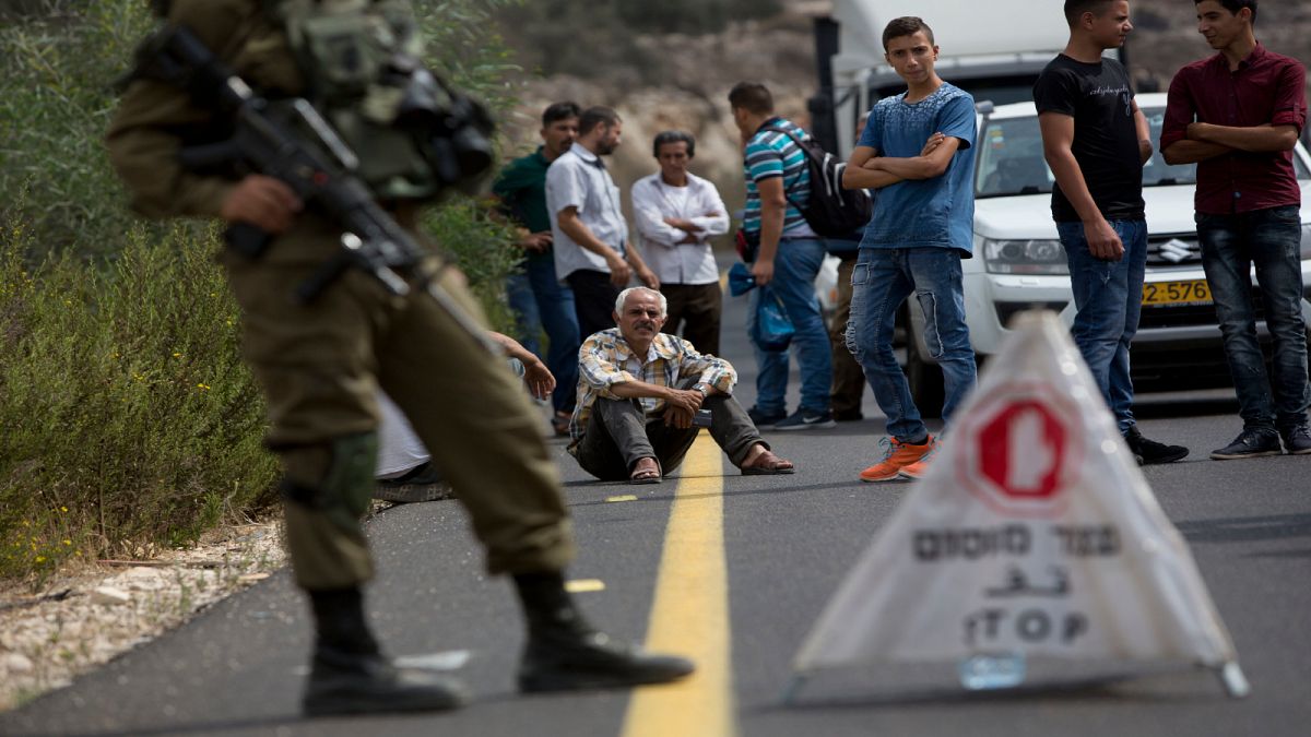 فلسطينيون ينتظرون أمام أحد الحواجز العسكرية الإسرائيلية في الضفة الغربية المحتلة