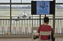 A woman sits in a wainting area before receiving an injection of the Covid-19 vaccine on the vaccination centre at the Brussels airport