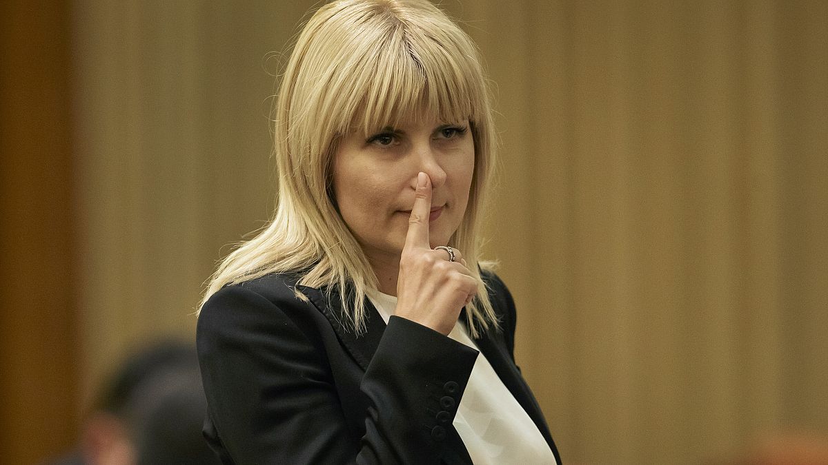 In this Monday, Feb. 9, 2015 file photo, Elena Udrea touches her nose after delivering a speech in parliament pleading with fellow lawmakers not to approve her arrest. 