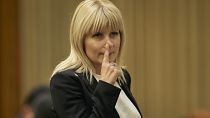 In this Monday, Feb. 9, 2015 file photo, Elena Udrea touches her nose after delivering a speech in parliament pleading with fellow lawmakers not to approve her arrest.
