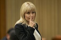 In this Monday, Feb. 9, 2015 file photo, Elena Udrea touches her nose after delivering a speech in parliament pleading with fellow lawmakers not to approve her arrest.