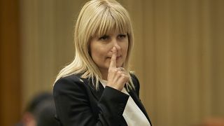 In this Monday, Feb. 9, 2015 file photo, Elena Udrea touches her nose after delivering a speech in parliament pleading with fellow lawmakers not to approve her arrest.