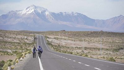 Migrantes venezolanos caminan por una carretera en el desierto de Atacama, Chile