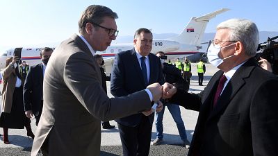 El presidente serbio Aleksandar Vucic, a la izquierda, y el miembro musulmán de la presidencia tripartita de Bosnia Sefik Dzaferovic intercambian en el aeropuerto de Sarajevo,