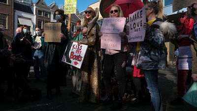 Trabajadoras sexuales portan pancartas en protesta por la desigualdad de trato y la estigmatización durante una manifestación en La Haya, Países Bajos, el 2 de marzo de 2021.