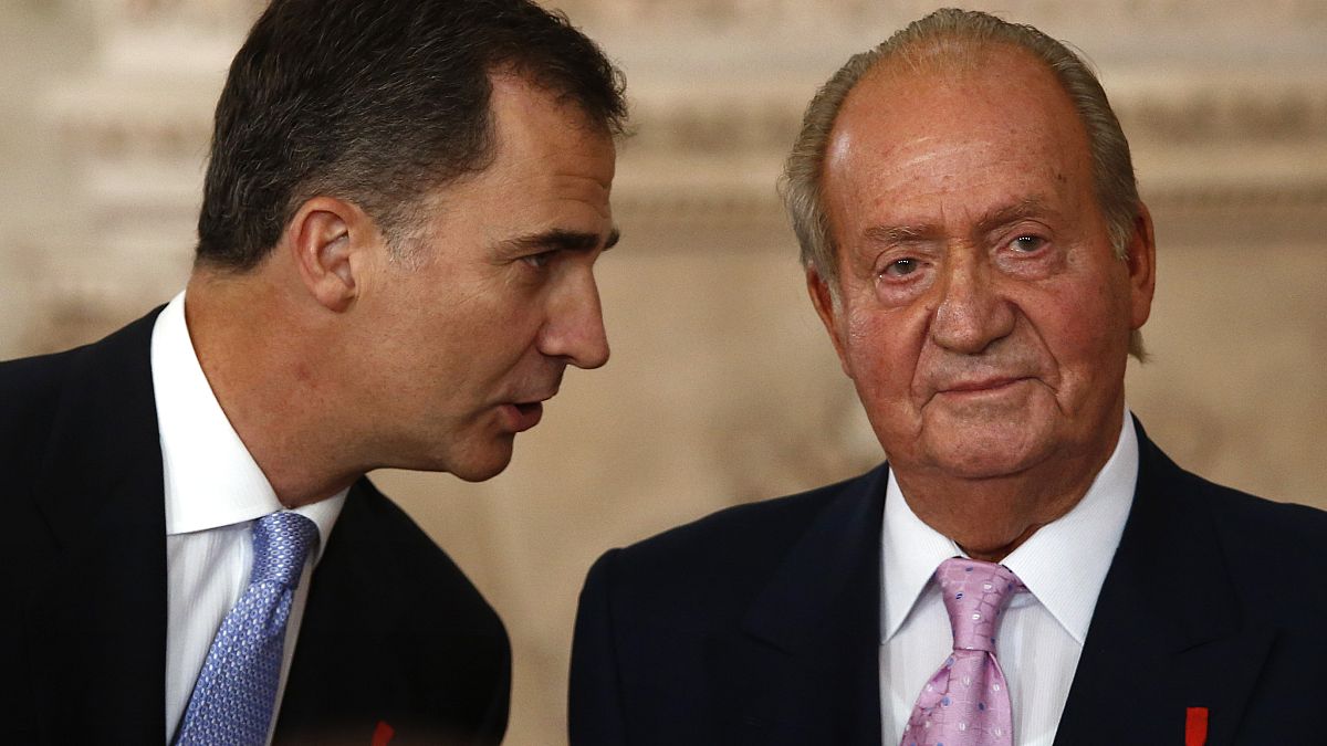 En esta foto de archivo del miércoles 18 de junio de 2014, el príncipe heredero Felipe habla con el rey español Juan Carlos después de firmar una ley de abdicación