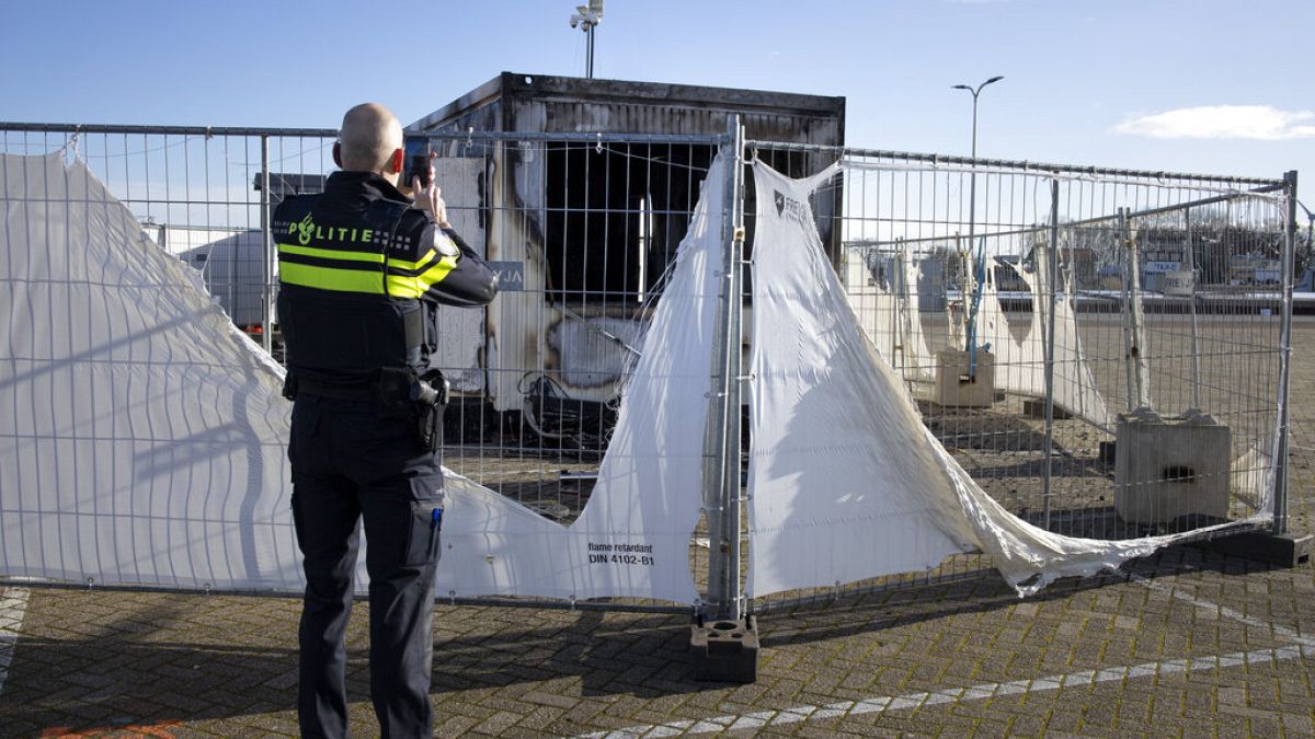 Archiv: Polizist eine ausgebrannte Coronavirus-Testanlage im Fischerdorf Urk in den Niederlanden, 24.01.2021