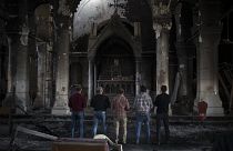 مصلون في كنيسة الحبل بلا دنس التي دمر تنظيم الدولة الإسلامية جزءاً منها في الموصل (أرشيف)
