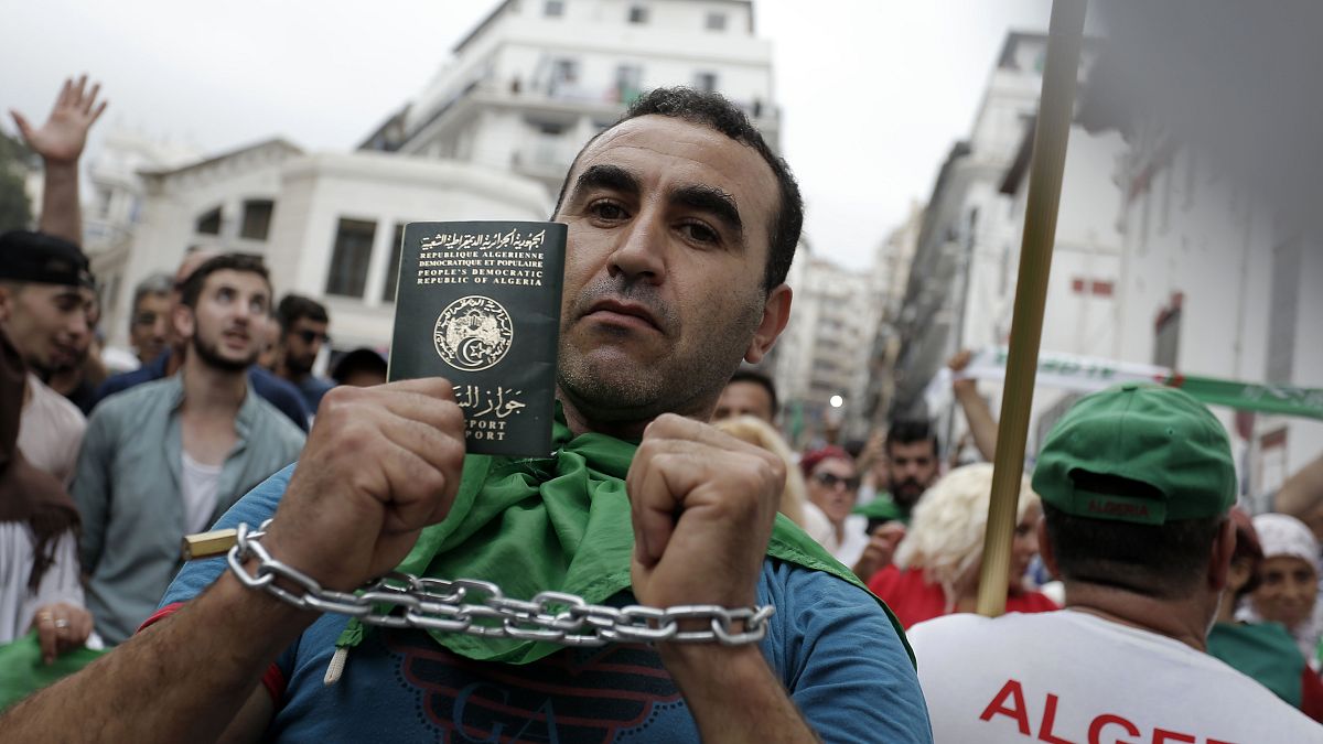 متظاهر يربط يديه بشكل رمزي ويظهر جواز سفره خلال مظاهرة في الجزائر العاصمة، 20 سبتمبر/ أيلول 2019