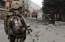 Katona védi a tűzoltókat, akik egy bombatámadás helyszínén dolgoznak