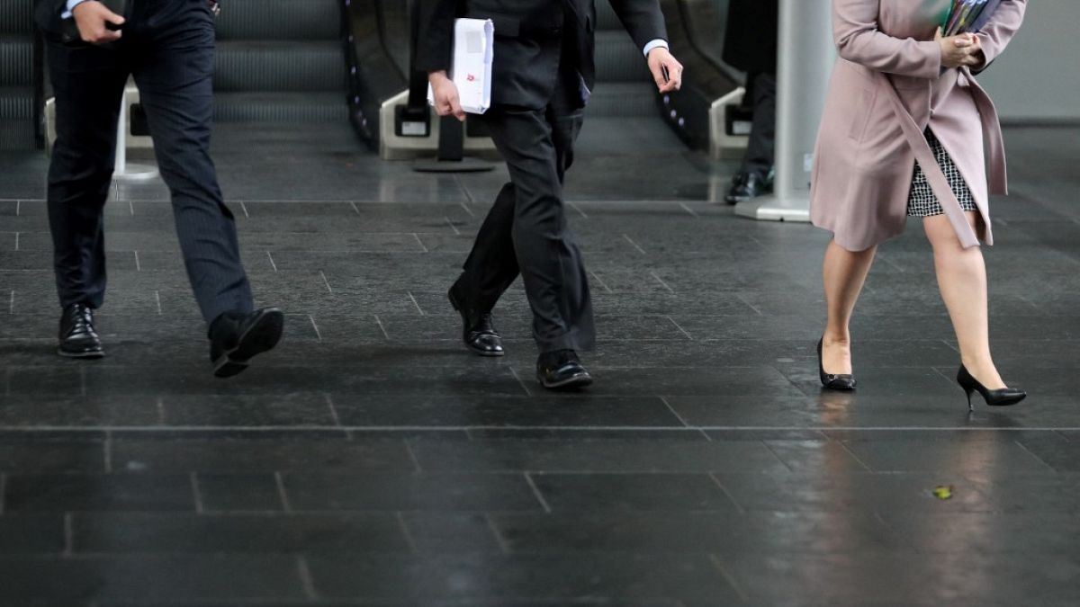 Business men and women walk in the City of London 