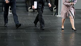 Business men and women walk in the City of London 