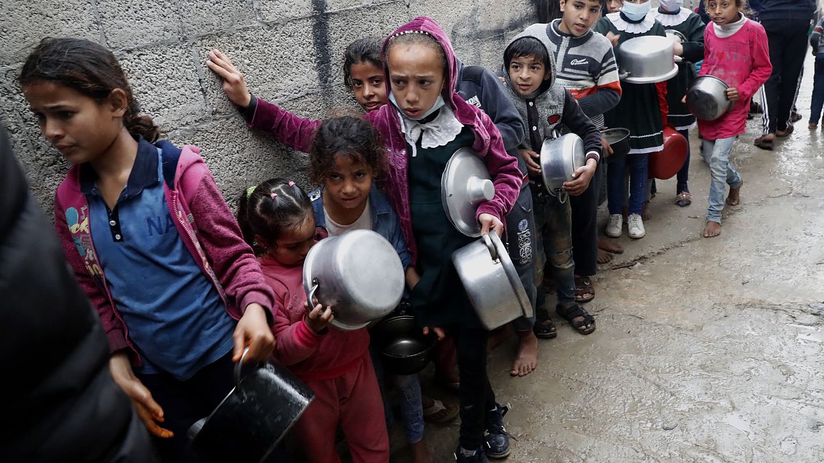أطفال فلسطينيون ينتظرون تلقي وجبات مجانية في قطاع غزة.  