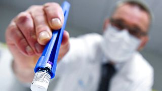 A health worker holds a vial of the Pfizer-BioNTech COVID-19 vaccine as they are thawed in a lab at the UZ Leuven hospital in Leuven, Belgium, Sunday, Dec. 27, 2020.