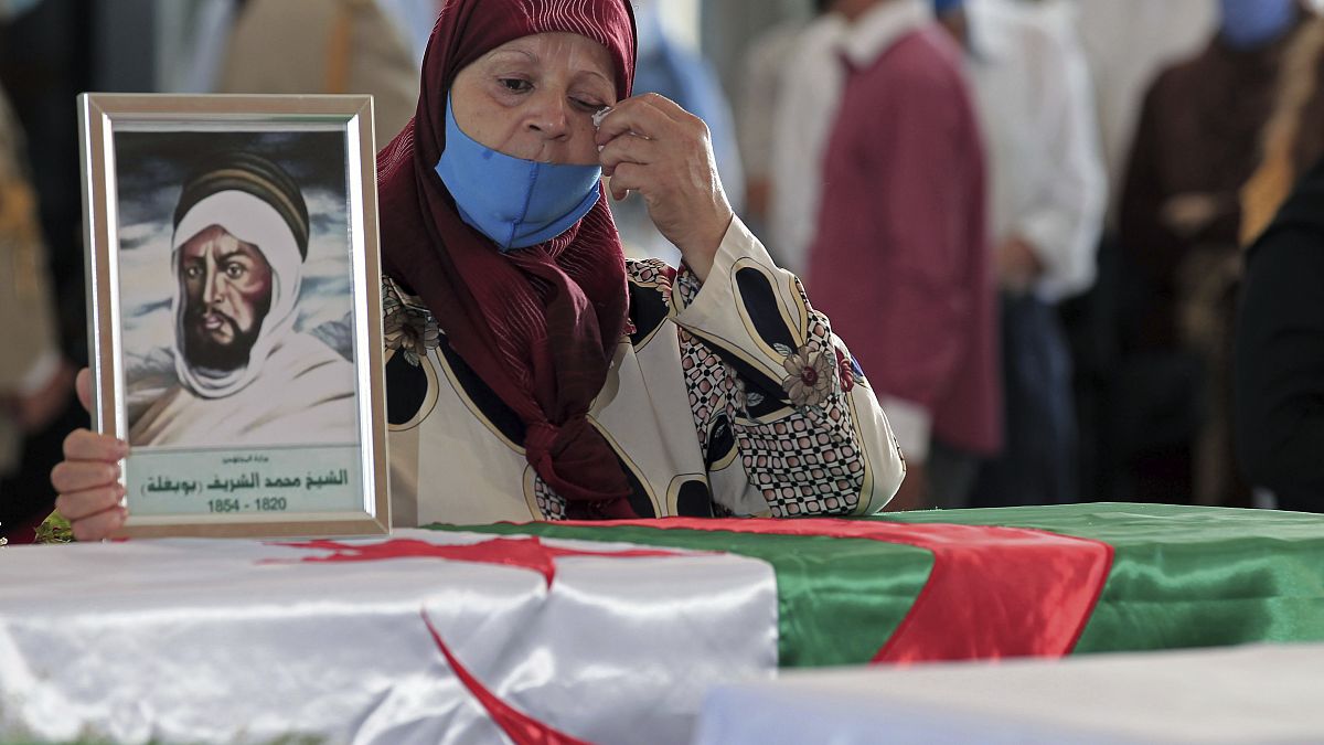 جزائرية تبكي على نعش واحد من 24 جزائريًا تم إعادة بقاياهم بعد إعدامهم في الجزائر العاصمة.