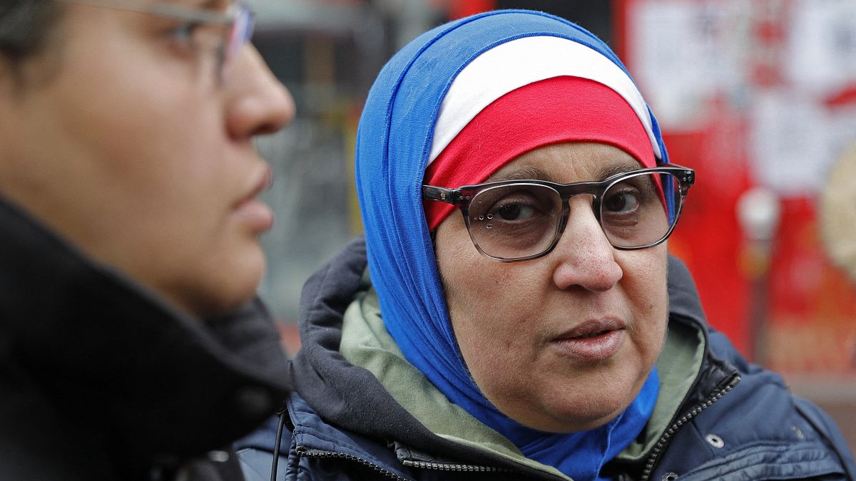 صورة من الارشيف - سيدة  محجبة بالوان العلم الفرنسي، الأزرق والأبيض والأحمر، خلال مسيرة في باريس احتجاجاً على الإسلاموفوبيا.
