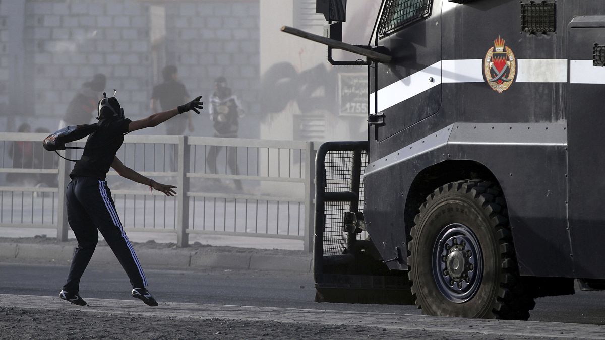 متظاهر بحريني يرمي سيارة للشرطة بقطعة لوح. 2013/03/15