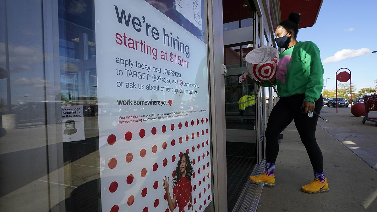 In this Sept. 30, 2020, file photo, a passerby walks past a hiring sign while entering a Target store in Westwood, Mass. 