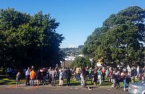 People gather on high ground in Whangarei, New Zealand, as a tsunami warning is issued