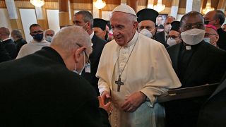 Pope Francis is greeted by a clergyman upon his arrival at the Syro-Catholic Cathedral of Our Lady of Salvation (Sayidat al-Najat) in the capital Baghdad